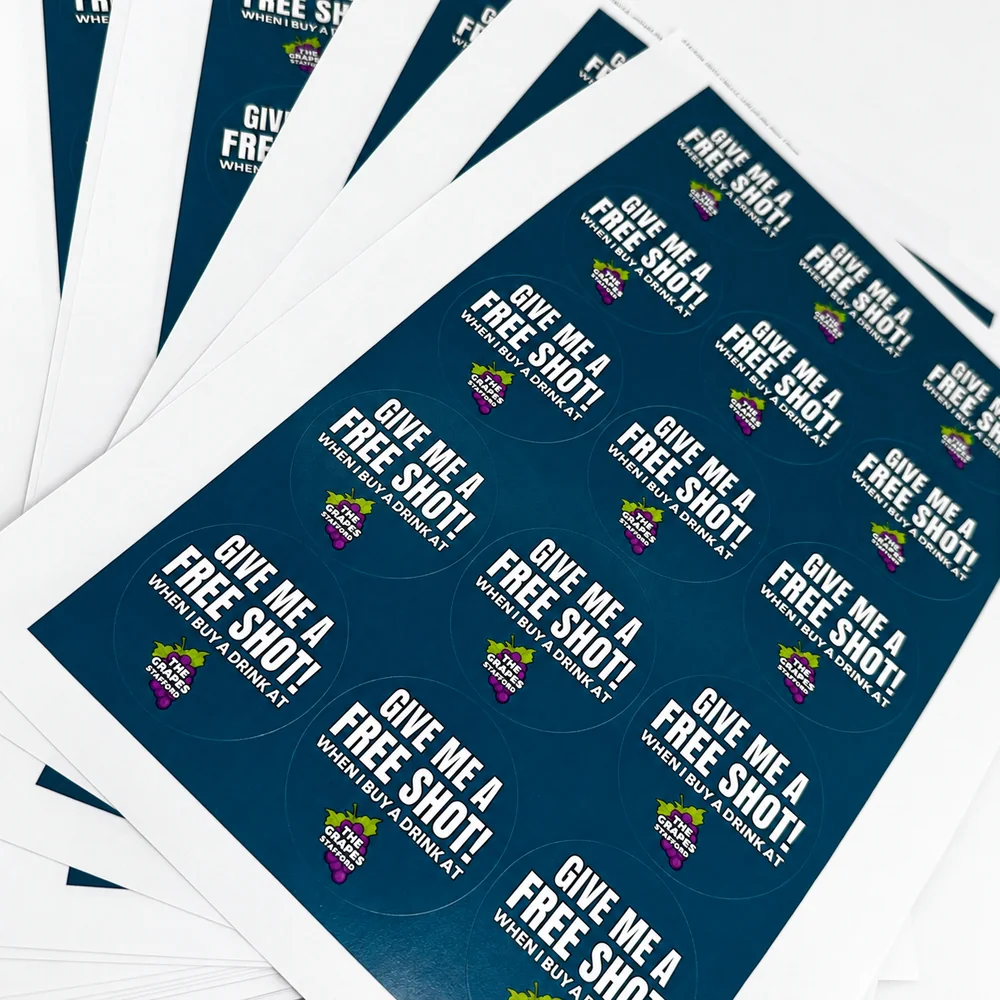 Sheets of round promotional stickers reading give me a free shot
