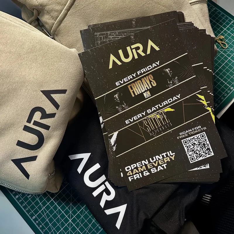 Aura promotional flyers beside matching branded clothing