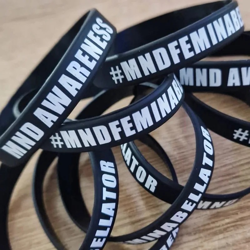 Black MND awareness wristbands with white lettering