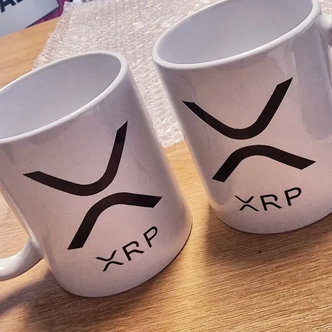 Two white mugs printed with a black XRP logo
