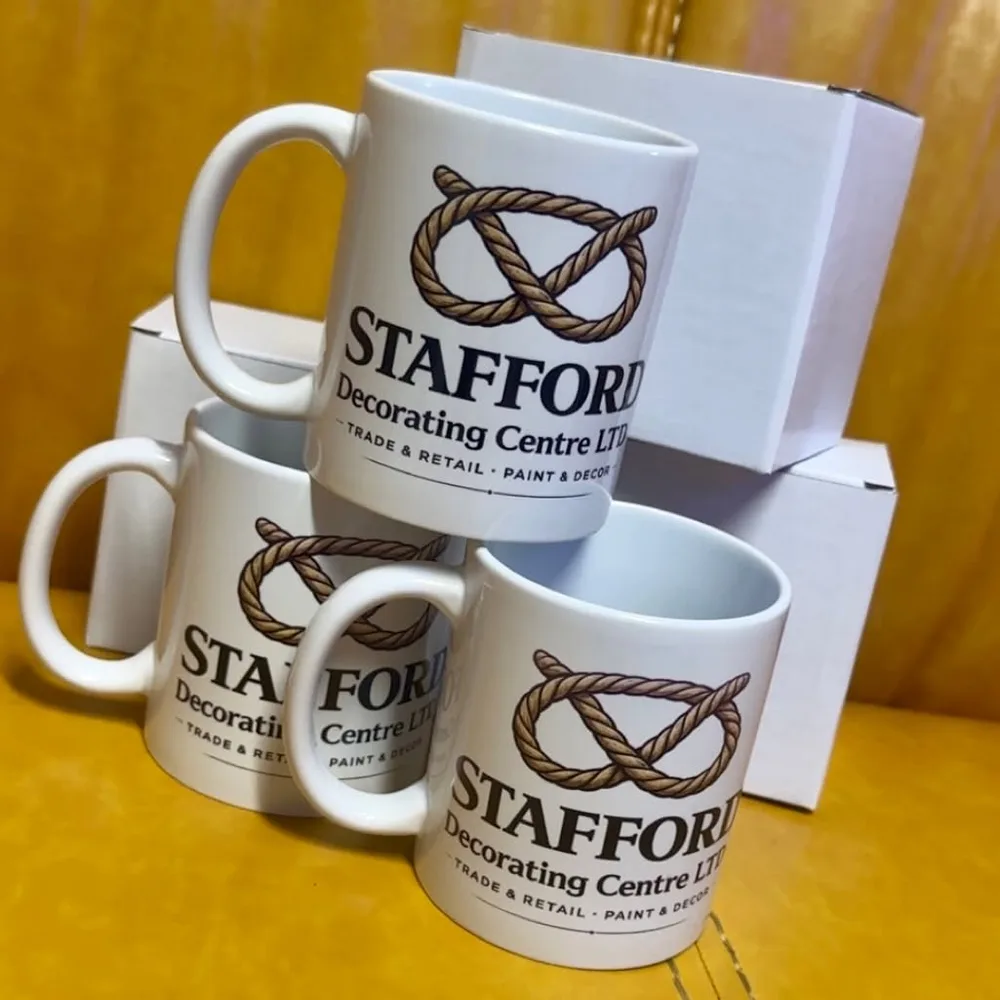 Three white mugs printed with the Stafford Decorating Centre logo